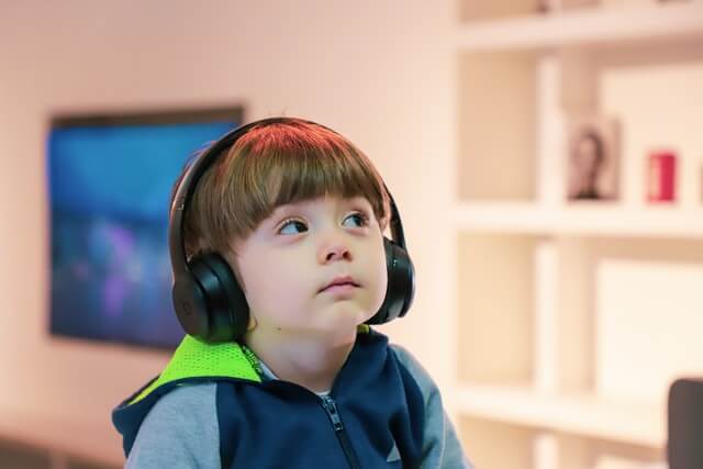 ヘッドホンで音楽を聴いている子供