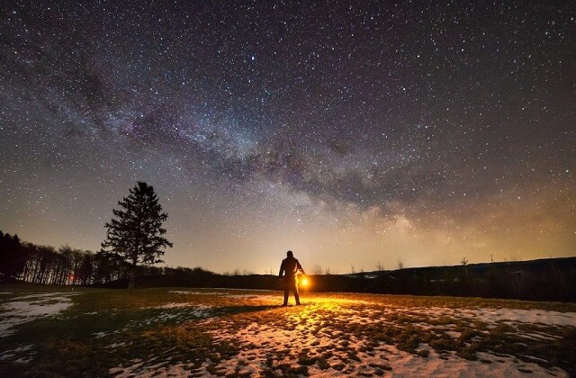 ランタンを持つ男性と星空